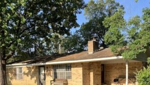 A single-story brick house with a covered porch, a small front yard, and a driveway. - Lake house with access to the best beach for swimming & fishing on Lake Hamilton (Hot Springs)