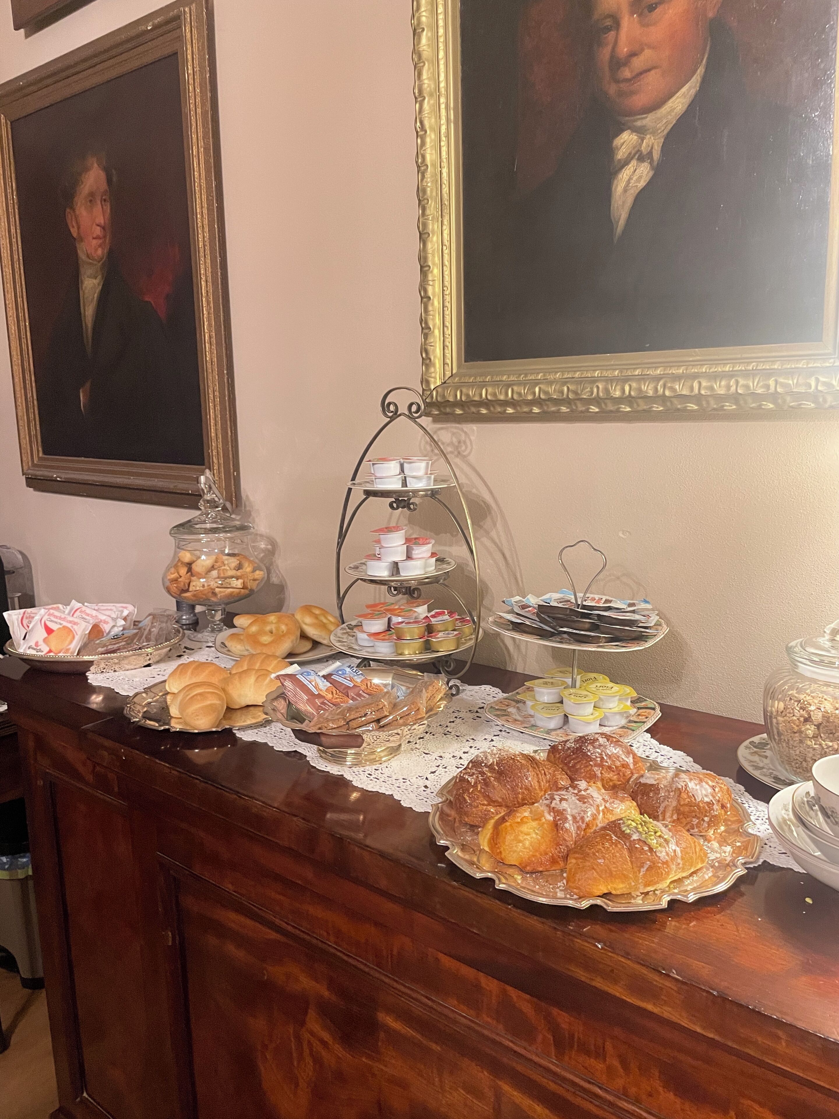 A buffet table with various pastries, breads, and desserts.