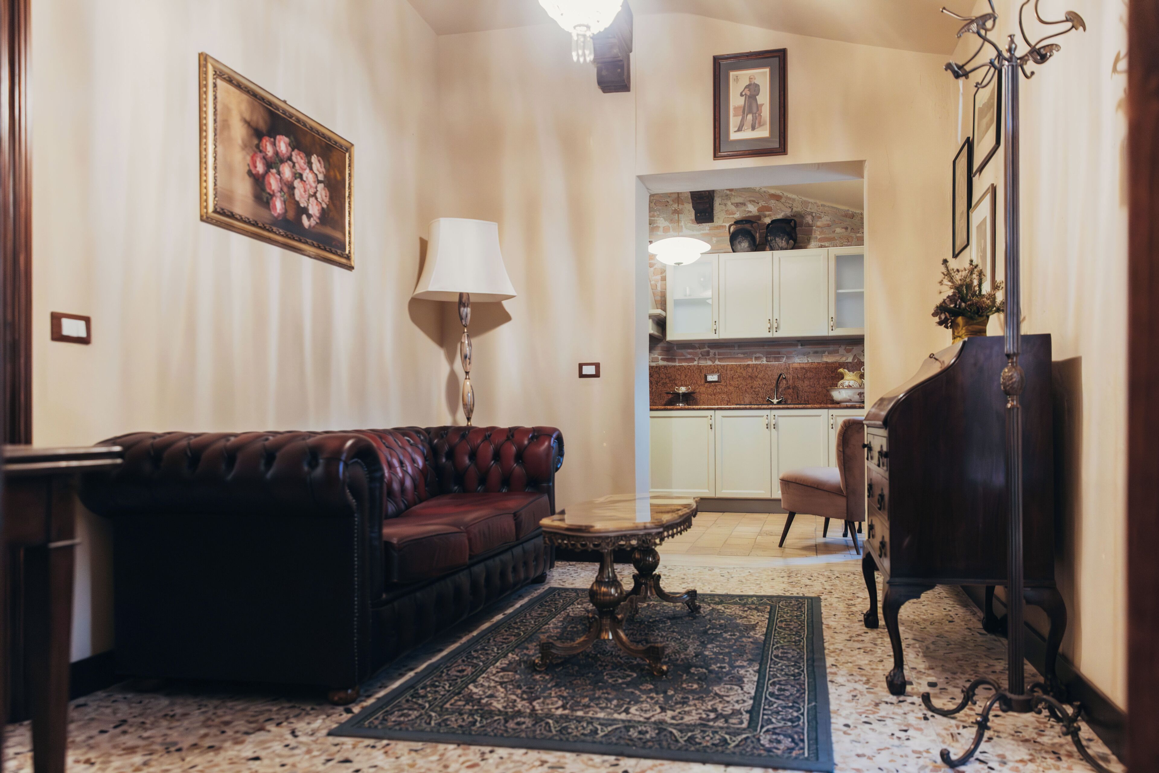 A living room with a leather sofa, a table, a lamp, and a rug.