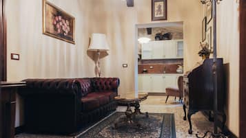 A living room with a leather sofa, a table, a lamp, and a rug.