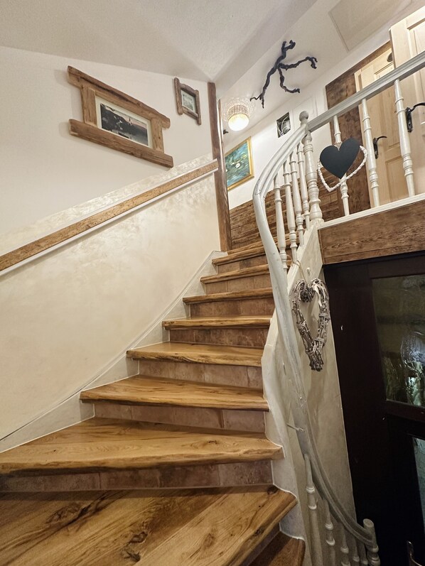 Una escalera de madera con barandillas blancas y una decoración con forma de corazón en la barandilla.