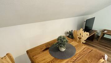 Una mesa de comedor de madera con una planta en maceta y un protector de mesa tejido.