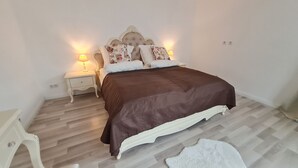 A bedroom with a large bed, two bedside tables, and a nightstand.