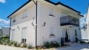 A two-story building with a balcony, a satellite dish, and a number '3' on the wall.