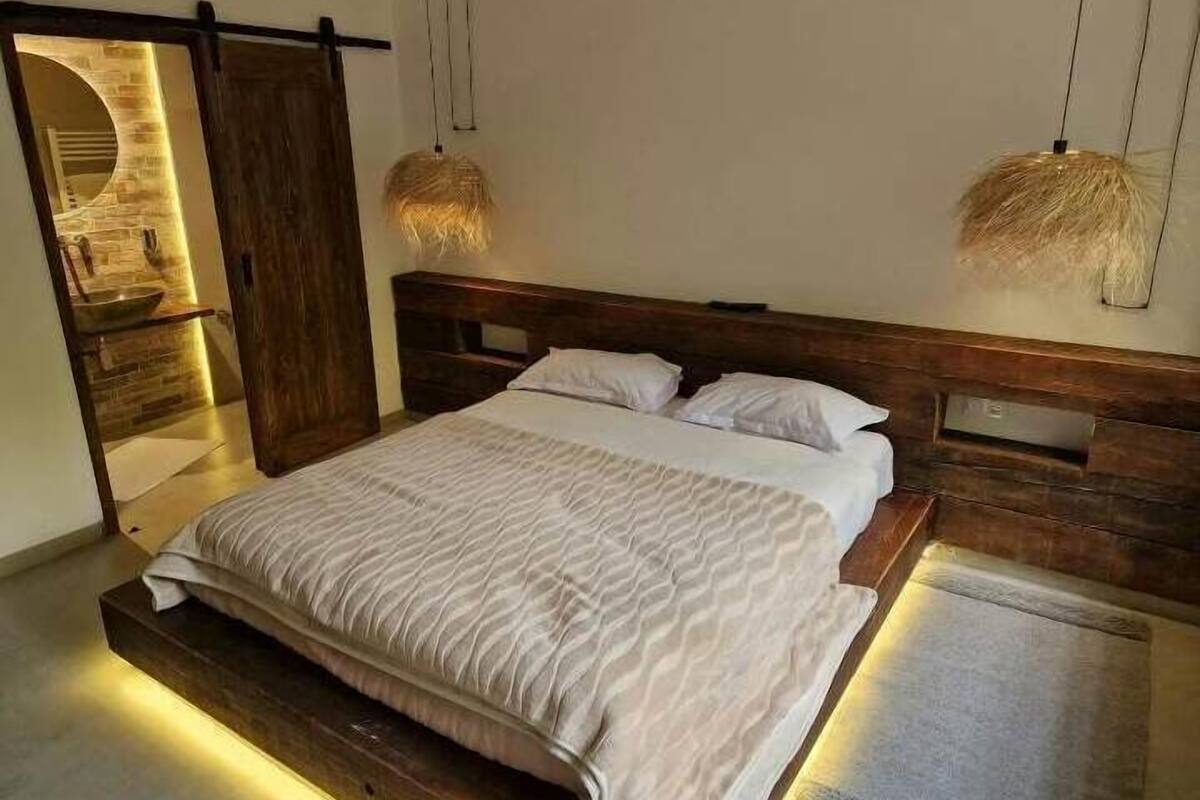 Habitación doble | Tabla de planchar con plancha y ropa de cama