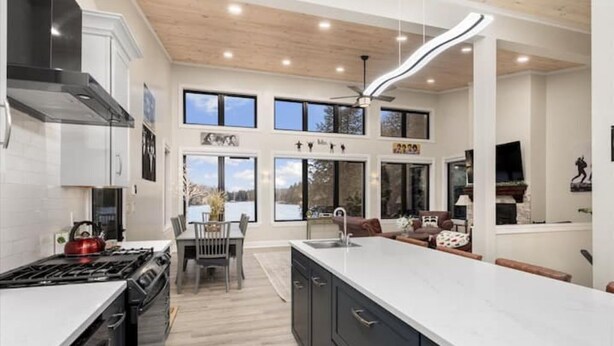 Una cocina moderna con una isla grande, electrodomésticos integrados y un comedor con vistas al exterior.