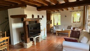 Un salon chaleureux avec un meuble TV en bois, un canapé et une table à manger.