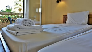 A hotel room with a bed, a wall-mounted lamp, and a view of the outdoors. - Elpida Hotel (Zakynthos)