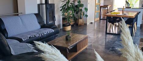 A modern living room with a sofa, coffee table, and potted plants.