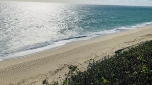 Una playa con cielo despejado y mar tranquilo.
