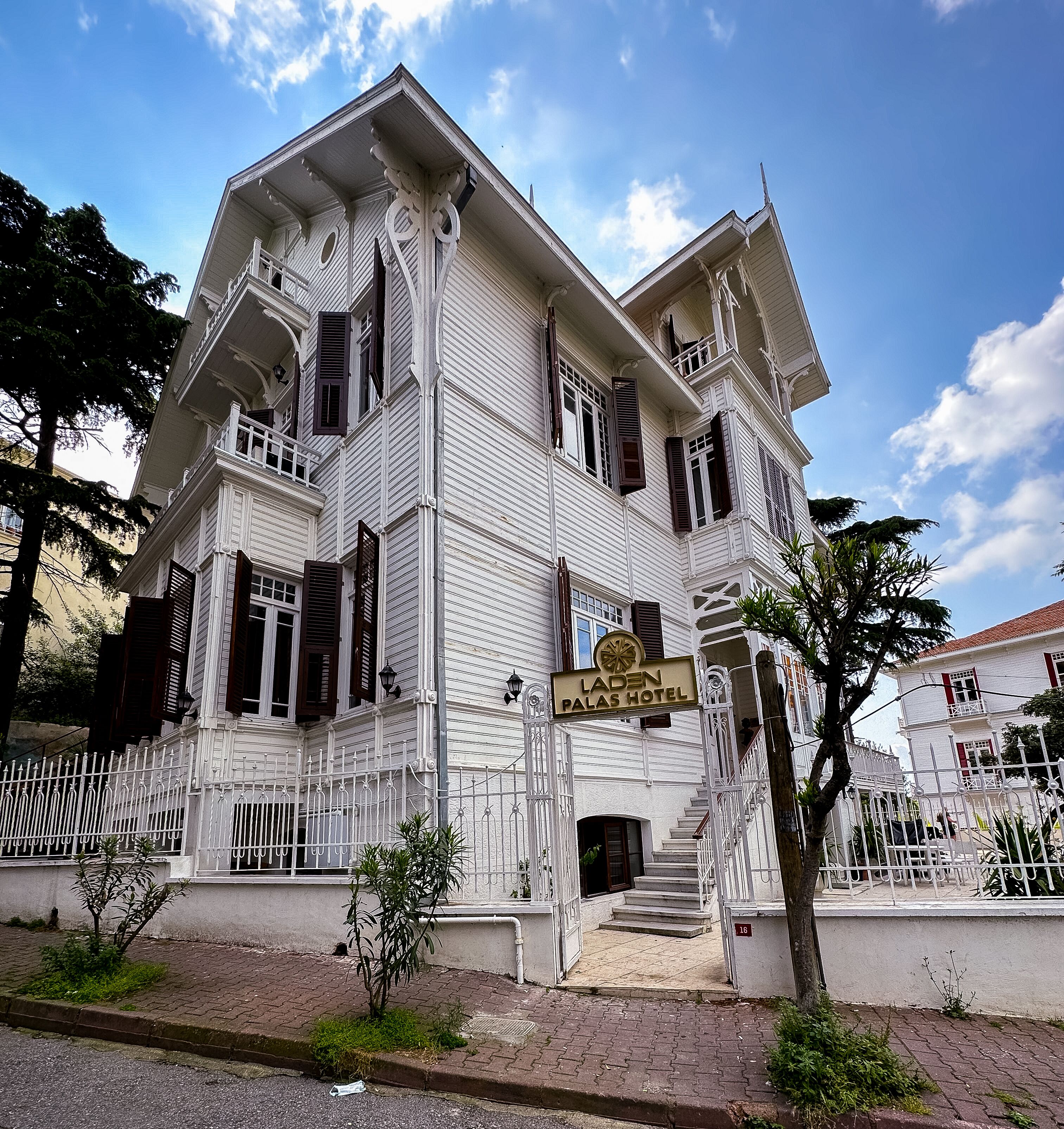 A white building with a sign reading "Laden Palas Hotel".