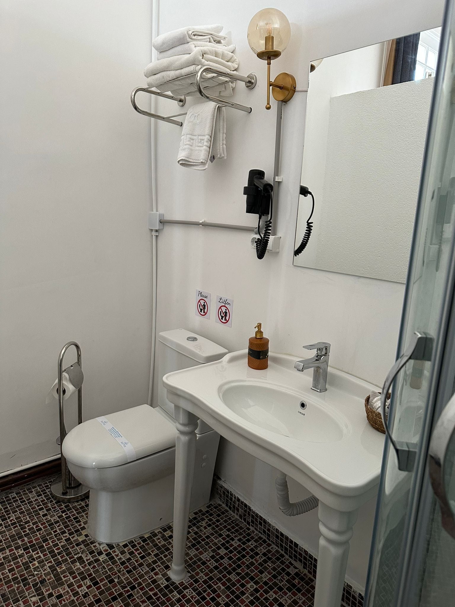 A bathroom with a toilet, sink, and towel rack.