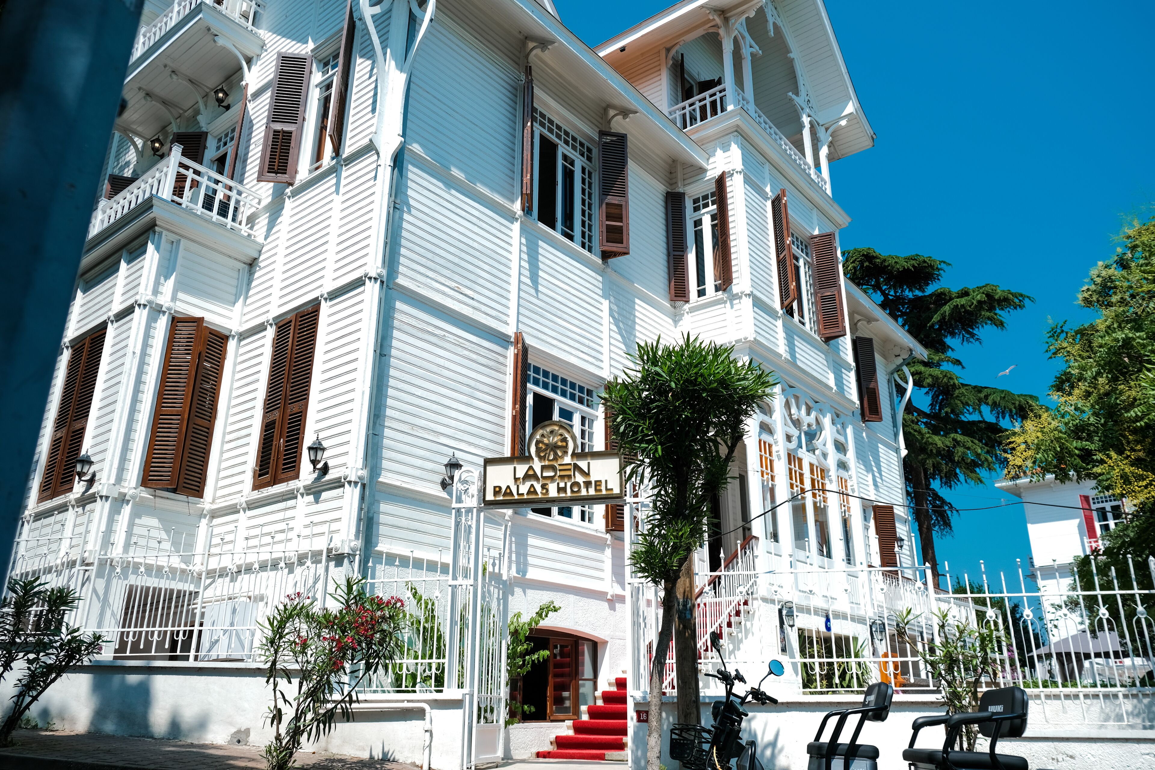 Un edificio blanco con un letrero que dice 'Laden Palace Hotel'.
