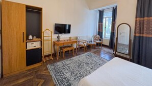 A bedroom with a bed, a desk, a chair, a television, a wardrobe, and a mirror. - Laden Palas Hotel Buyukada (Adalar)