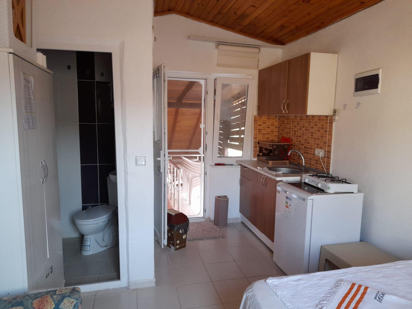 A compact kitchen with a sink, stove, and cabinets.
