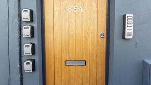 A wooden door with the number 85A, a mail slot, and five Master locks on the wall. - At the level - (2 bed flat) (Brighton and Hove)