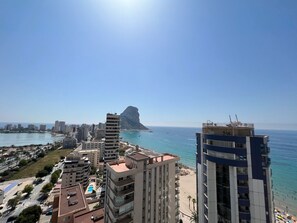 A coastal cityscape with high-rise buildings, a beach, and a prominent rock formation in the distance. - Alq 066 Atico Bahia del Sol (Calpe / Calp)