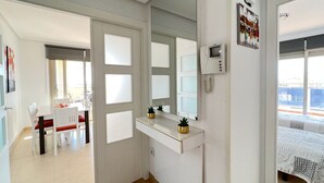 Ein Hotelzimmer mit einem Bett, einem kleinen Schreibtisch mit Stuhl, einem Spiegel und einem Fenster.