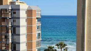 Un hotel de varios pisos con balcones con vista a la playa y al océano.