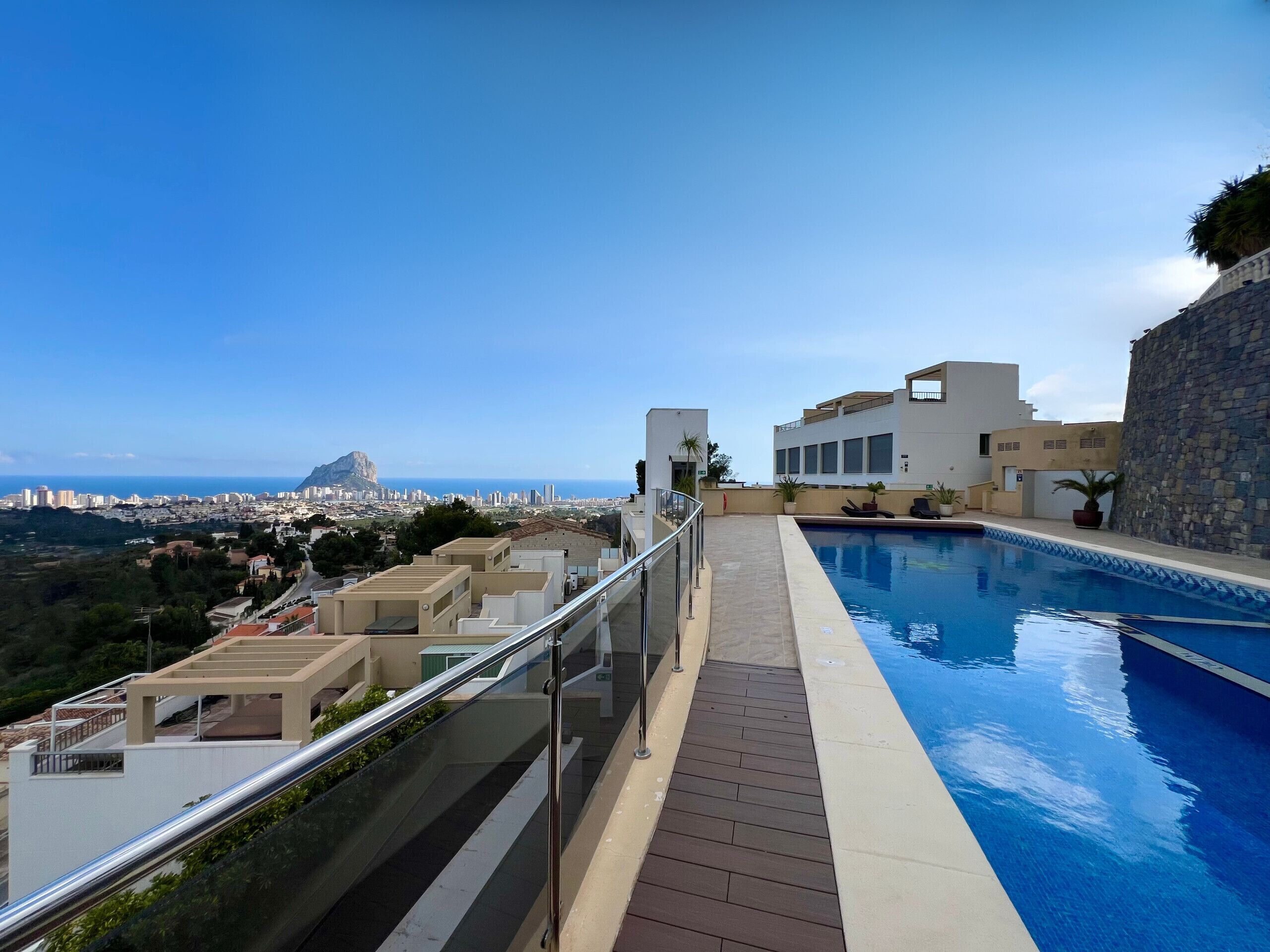 A rooftop pool with a clear view of the cityscape and a prominent mountain in the distance.