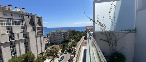 A high-rise building with a view of the sea and other buildings.