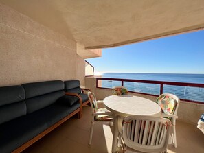 A balcony with a sofa, chairs, and a table. - Alq 178 Amatista Apartment (Calpe / Calp)