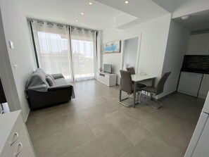 A modern apartment with a dining area, a sofa, a TV, and a kitchen. - Alq 229 Calpe Beach (Calpe / Calp)