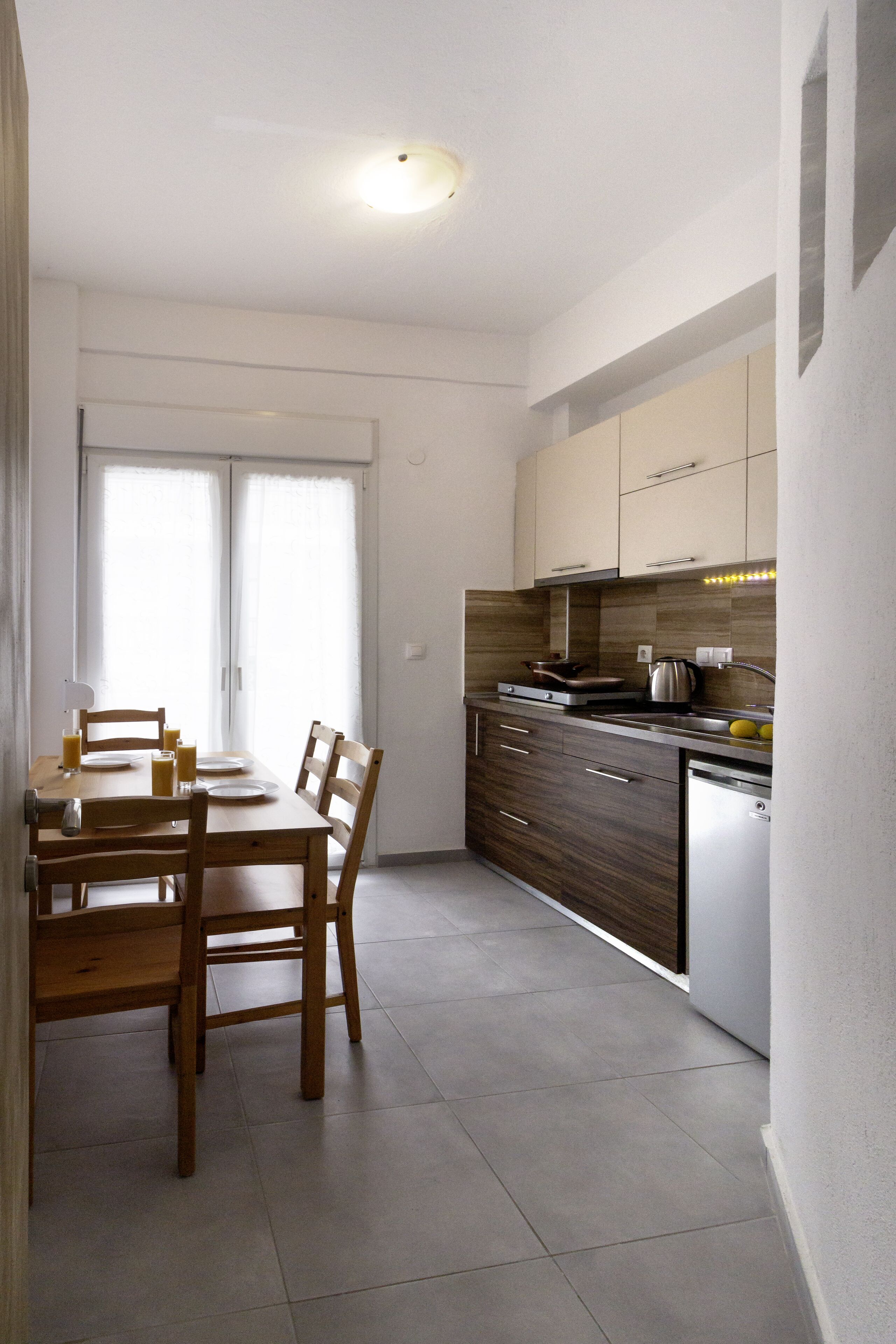 Une cuisine moderne équipée d’une table à manger, de chaises, de placards et d’un lave-vaisselle.