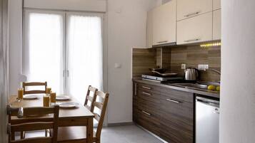 Une cuisine moderne équipée d’une table à manger, de chaises, de placards et d’un lave-vaisselle.
