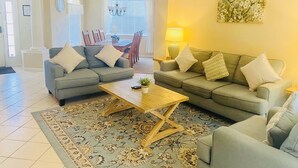 Ein Wohnzimmer mit zwei Sofas, einem Couchtisch und einem gemusterten Teppich.