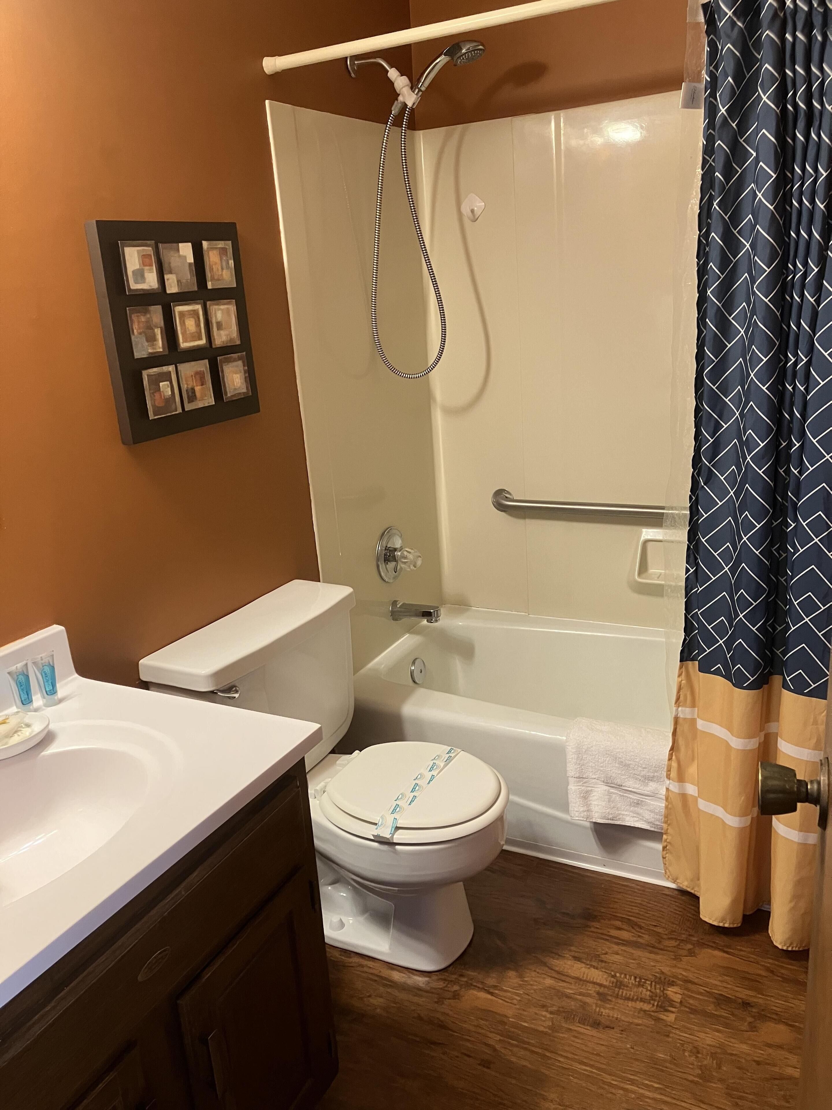 A bathroom with a toilet, sink, bathtub, and shower.
