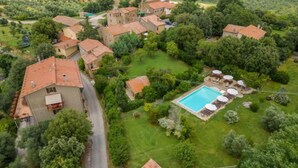 A residential area with multiple houses, a swimming pool, and a well-maintained lawn.