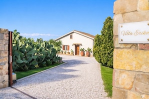 A villa with a gravel driveway, a stone wall, and a sign reading 'Villa Erika'. - Villa Erika SicilyMyHome (Ispica)
