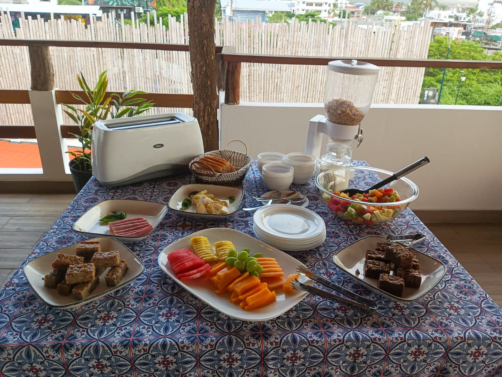 Ein Frühstücksbuffet mit verschiedenen Speisen und einem Toaster auf einem Balkon.