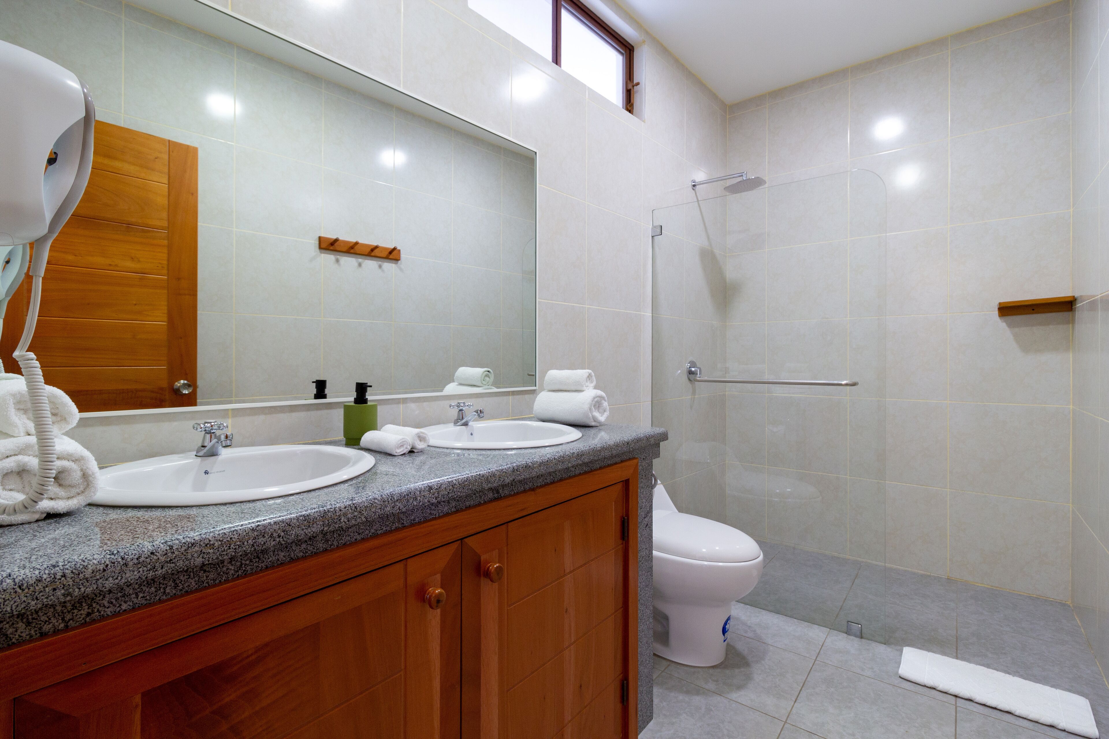 Un baño con lavamanos, espejo y ducha.