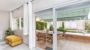 Un salon moderne doté d’une porte-fenêtre coulissante donnant sur un patio extérieur.