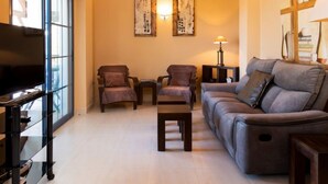 A living room with a sofa, two armchairs, a coffee table, a TV, and artwork on the walls. - Mirador Galera Playa Free Padel by Interhome (Almuñécar)