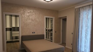 Een slaapkamer met een bed, kast en spiegel.