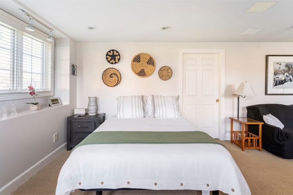 A bedroom with a bed, bedside tables, a lamp, a chair, and wall decorations.