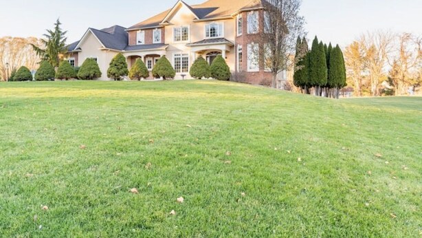 A large, two-story house with a well-maintained lawn in front. - Red Fox Run Hideaway (Victor)