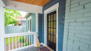 A porch with a white railing, a broom, and a doormat. - Artisan Gem - 2 BR / 1 Bath (Spruce Pine)