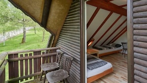 A cozy attic bedroom with a wooden sloped ceiling, a small bed with a pillow, a chair, and a view of a green landscape. - Rumpelstilzchen by Interhome (Frankenau)