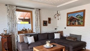 Una sala de estar moderna con un sofá modular, una mesa de centro de madera y un cuadro en la pared.