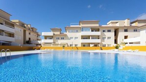 A swimming pool surrounded by multi-story buildings with balconies. - Home2Book Comfy Apt Puertito de Güímar, Pool (Puertito de Güímar)