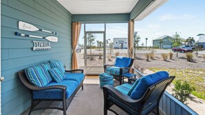 A covered porch with wicker furniture, a view of a parking lot, and a sign reading "TOWELS".
