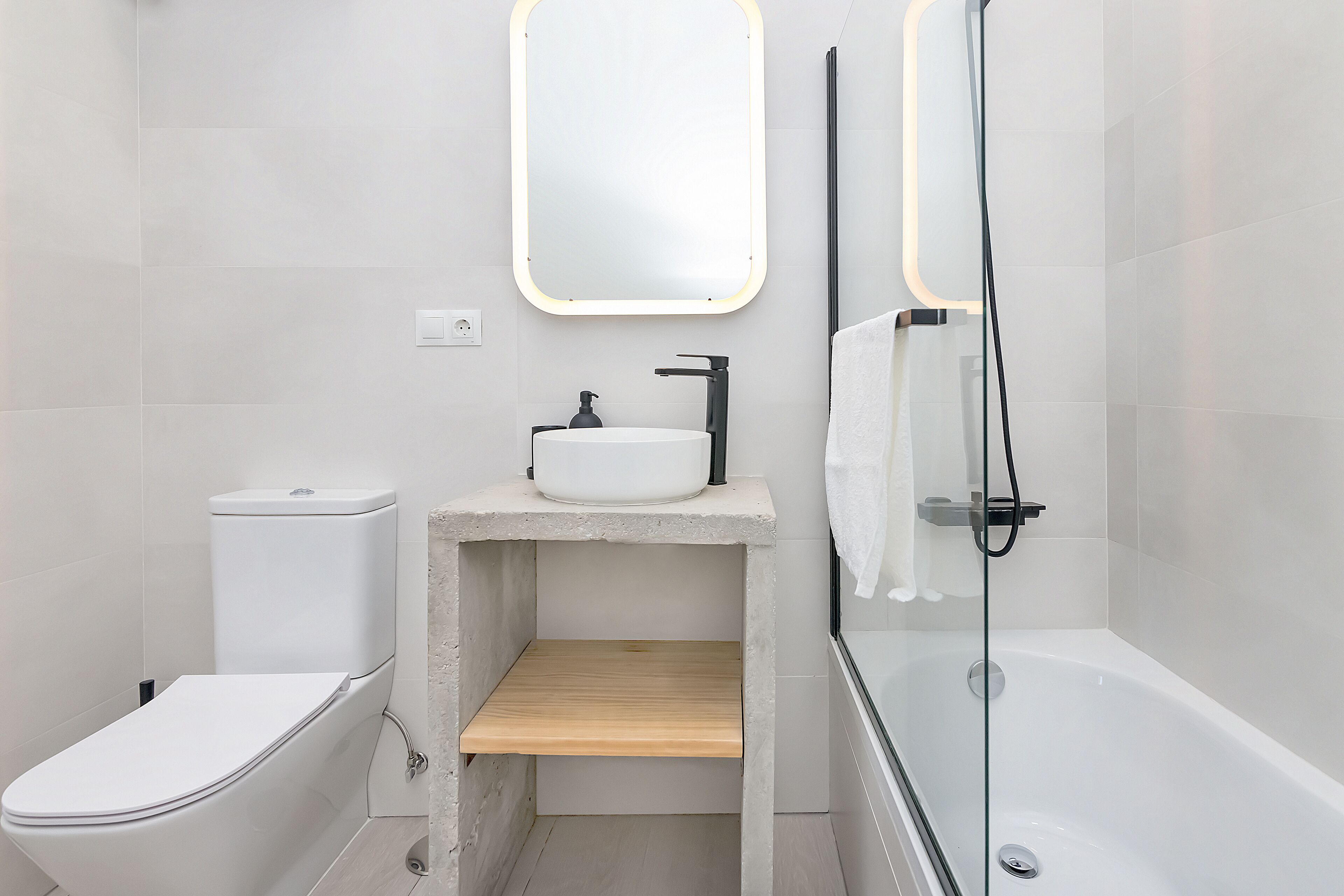 A modern bathroom with a toilet, sink, and shower.