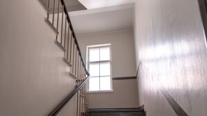 A staircase with wooden handrails and a window at the top. - 2ndhomes Comfy Studio by Esplanade Park (Helsinki)