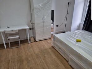 Comfortable room with a bed, desk, and wardrobe.