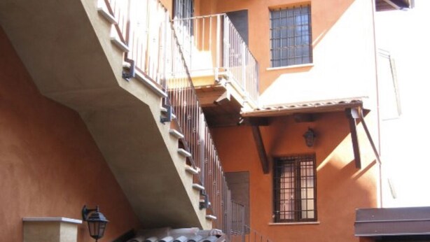 A courtyard with a stone oven, a small table, and a staircase leading to an upper level. - 2 Bedroom Bed & breakfast in Condove (Condove)