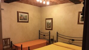 A small, cozy room with two single beds, a wooden chair, and two framed pictures on the walls. - 2 Bedroom Bed & breakfast in Condove (Condove)